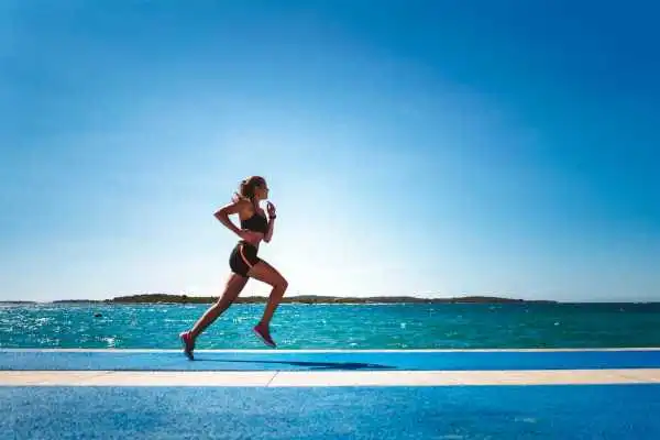Woman running showing strong leg muscle Portland Bill